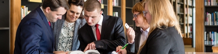 Biblioteka - Grupa słuchaczy wpatrująca się w książkę