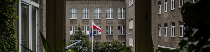 Widok z okna na dziedziniec KSAP i powiewające flagi