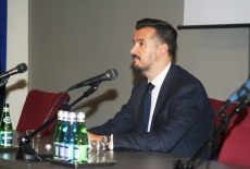 Ambasador Pejovic siedzi przy stole prezydialnym.