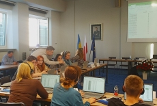 uczestnicy szkolenia siedzą przy ławkach i pracują przy komputerach