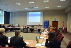 Uczesnicy wizyty siedzą na sali przy stołach, a Dyrektor Jan Pastwa przemawia