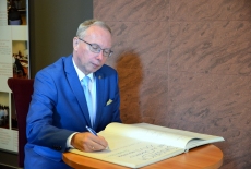 Wojewoda Mazowiecki Jacek Kozłowski wpisuje się do księgi pamiątkowej KSAP.