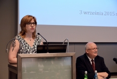 Prezes Stowarzyszenia Absolwentów KSAP Urszula Kulisiewicz przemawia przy mównicy. Po lewej przy stole prezydialnym siedzi Dyrektor KSAP Jan Pastwa.