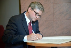 Szef Biura Bezpieczeństwa Narodowego Paweł Soloch wpisuje się do księgi pamiątkowej.