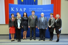Uczestnicy spotkania na tle baneru KSAP i flag polskich i Unii Europejskiej.