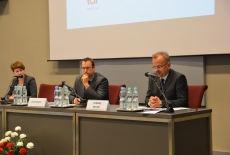 Przy stole prezydialnym siedzi od lewej: Katarzyna Woś, Jan Hofmokl, Tomasz Bolek