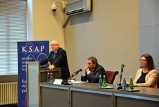 Jan Pastwa Dyrektor KSAP przemawia przy mównicy. Za stołem prezydialnym siedzą pozostali goście z Ambasadorem Alessandro de Pedys na czele. 