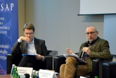 Na fotelach w prezydium siedzą od lewej dr Betkiewicz i prof. Krzysztof Jasiecki. W tle po lewej stronie niebieski baner KSAP.