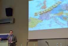 Prowadzący wykład stoi przy mównicy, obok na dużym ekranie wyświetlona mapa Europy z napisem: Brexit.