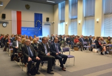 Uczestnicy spotkania w auli KSAP. W trle flagi Polski i Unii Europejskiej oraz baner KSAP.