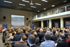 Uczestnicy spotkania w auli KSAP. W tle prezentacja na ekranie.