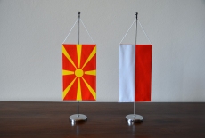Na stole stoją proporczyki - flagi Macedonii i Polski.