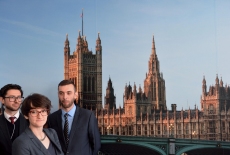 Zdjęcie grupowe słuchaczy KSAP na tle fototapety przedstawiającej budynek Parlamentu w Londynie.