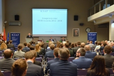 Goście siedzą na sali, Dyrektor Jan Pastwa przemawia przy mównicy, a Minister Morawicki i Minister Dowiat-Urbański siedzą przy stole prezydialnym.