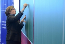 Profesor Julia Prats pisze na dużej zielonej tablicy.