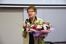 prof. Maria Gintowt-Jankowicz stoi z dużym bukietem kwiatów