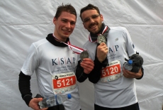 Dwóch reprezentantów KSAP stoi prezentując medale