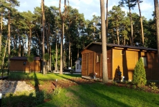W lesie stoją trzy drewniane domy 