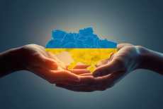dwie dłonie trzymają mapę Ukrainy w barwach flagi