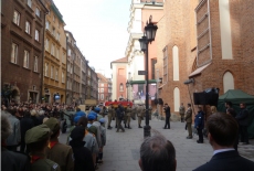 Żołnierze wnoszą do koścoła trumnę. na ulicy tłum.