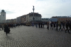 Przed pomnikiem Zygmunta przechodzą żałobnicy.