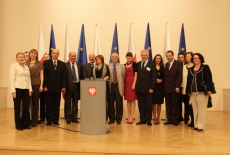 Zdjęcie grupowe na tle flag Polski i UE