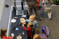 Dzieci bawią sie przy stole gdzie stoję mikrofony
