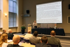 profesor Andrzej Wierzbicki stoi i mówi do mikrofonu przed nim widać siedzących gości