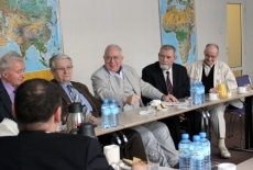 profesor Andrzej Wierzbicki oraz inni goście siedzą w ławkach i rozmawiają