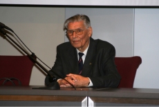 Profesor Włodzimierz Bojarski siedzi przy stole prezydialnym