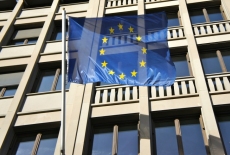 Flaga Unii Europejskiej powiewająca na zewnątrz przed budynkiem .