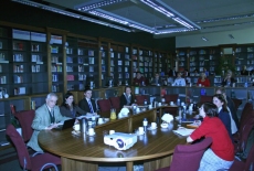 prof. Witold Mikułowski oraz goście spotkania siedzą przy stole w bibliotece KSAP