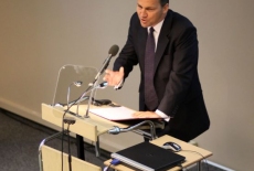 minister Sikorski stoi przy mównicy i przemawia