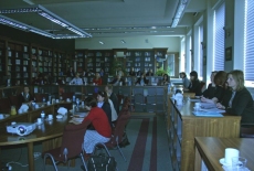 goście spotkania siedzą przy stole w bibliotece KSAP