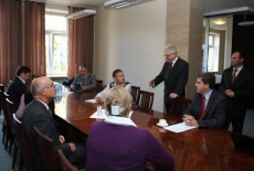 przedstawiciele Akademii Zarządzania Publicznego w Rotsowie siedza przy stole. Dyrektor KSAP stoi i mówi