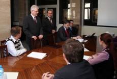przedstawiciele Akademii Zarządzania Publicznego w Rotsowie siedza przy stole. Dyrektor KSAP stoi i mówi