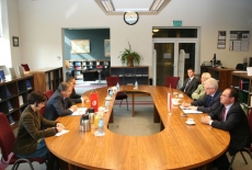 przedstawiciele obu stron spotkania siedza przy stole w bibliotece KSAP