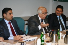 Trzech przedstawicieli delegacji z Iraku siedzi przy stole