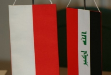 flagi Polski i iraku stoją na stole