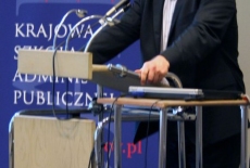Pan Grzegorz Górski stoi przy mównicy i przemawia