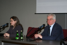 Pani Katarzyna Szarkowska siedzi przy stole i mówi do mikrofonu, obok siedzi Dyrektor KSAP Jacek Czaputowicz 