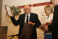 Władysław Bartoszewski trzyma w ręku otrzymany dyplom