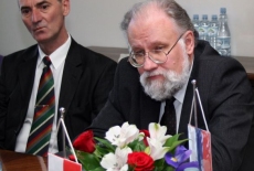 Pan Vladimir Churov siedzi przy stole obok siedzi Pan