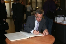 Tomasz Nałęcz wpisuje się do księgi pamiątkowej