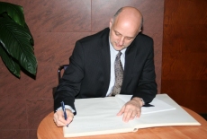  Pan Minister Jerzy Pomianowski wpisuje sie do księgi pamiątkowej