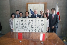 Zdjęcie grupowe uczestnicy trzymają plakat z Chińskimi literami