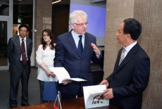 Dyrektor KSAP rozmawia z przedstawicielem delegacji Chin trzyma w ręku książkę