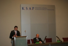 Nikola Poposki, Minister Spraw Zagranicznych Republiki Macedonii stoi na mównicy i przemawia obok przy stole prezydialnym siedzi Marek Haliniak