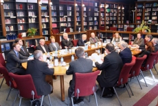 Uczestnicy posiedzenia Rady siedzą przy stole w bibliotece KSAP