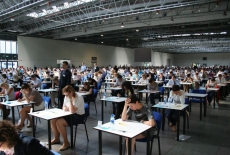 Sala egzaminacyjna, kandydaci siedzą przy stolikach i piszą egzamin